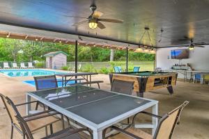 a patio with ping pong tables and chairs and a pool at Quaint Table Rock Lake Hideout with Pool Access in Reeds Spring