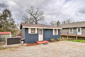 a blue house with a driveway in front of it at Quaint Table Rock Lake Hideout with Pool Access in Reeds Spring