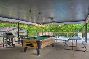 a pool table on a patio with a pool table at Quaint Table Rock Lake Hideout with Pool Access in Reeds Spring