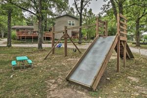 a wooden playground with a slide and a chair at Quaint Table Rock Lake Hideout with Pool Access in Reeds Spring