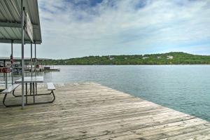 a wooden dock with a bench on top of the water at Quaint Table Rock Lake Hideout with Pool Access in Reeds Spring