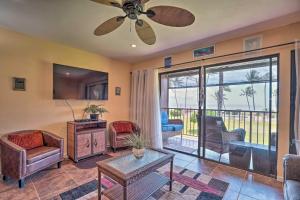 a living room with a ceiling fan and a sliding glass door at Breezy Kaunakakai Retreat with Community Pool! in Kaunakakai