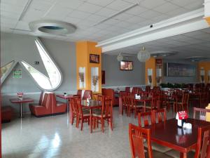uma sala de jantar com mesas e cadeiras e uma janela em Leo Hotel em Jerez de García Salinas
