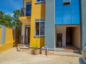 a yellow and blue building with a balcony at Keisha Luxury Furnished Apartment Bukoto in Kampala