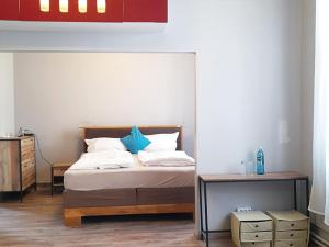 a bedroom with a bed with blue pillows and a table at Hotel Blüchertal in Bacharach