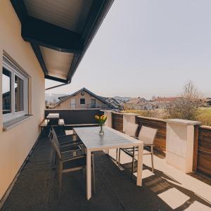 a patio with a table and chairs on a balcony at Große Ferienwohnung mit Balkon und perfekter Lage in Eggenthal