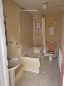 a bathroom with a tub and a toilet and a sink at ROYAL OAK in Kinnersley