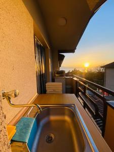 a bathroom with a sink on a balcony with the sunset at Villa Koceski in Peštani