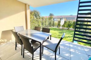 eine Terrasse mit einem Tisch und Stühlen auf dem Balkon in der Unterkunft IVOIRE COTTAGE Piscine in Boulouris-sur-Mer