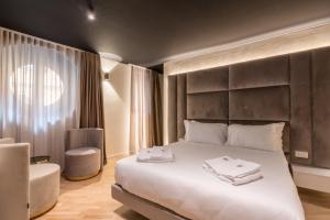 um quarto com uma grande cama branca e uma cadeira em Brera Luxury Apartment near Duomo With Wifi em Milão