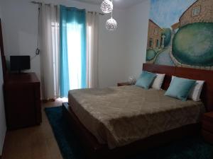 モンサントにあるQuinta da Pedra Grandeのベッドルーム(青い枕の大型ベッド1台付)