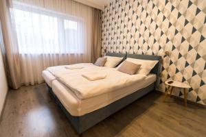 Un pat sau paturi într-o cameră la Thermal Lux Weninger Apartman