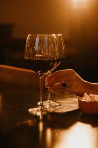 una persona sosteniendo una copa de vino en una mesa en Hotel Spa Azteca Barcelonnette en Barcelonnette