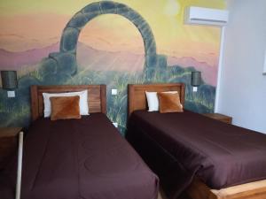 twee bedden in een kamer met een schilderij aan de muur bij Quinta da Pedra Grande in Monsanto +15 foto's