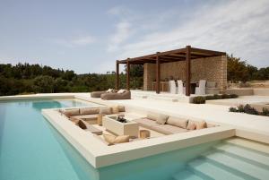 a pool with couches and a pavilion at Sui Generis Villa in Pesádha