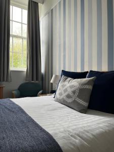 a bedroom with a bed with a pillow and a window at Berry Head Hotel in Brixham