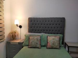 a bedroom with a bed with a large headboard and pillows at Luxury Department Tlaquepaque in Guadalajara