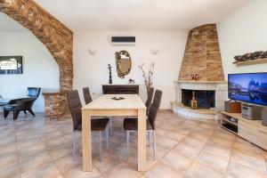a dining room with a table and a fireplace at VILLA KONSTANTINA Sidari in (( Sgoúrna ))