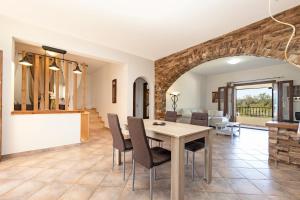 a dining room and living room with a table and chairs at VILLA KONSTANTINA Sidari in (( Sgoúrna ))