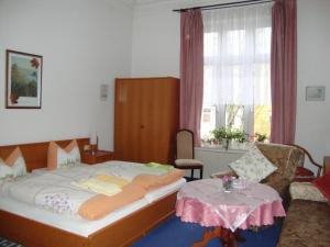 
a bedroom with a bed, desk, chair, and window at Haus am Pfaffenteich in Schwerin
