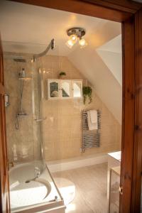 a bathroom with a shower with a toilet and a sink at Innes House Bed & Breakfast in Acharacle