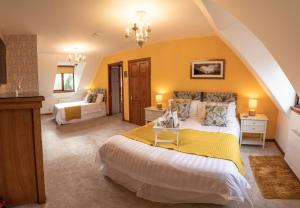 1 dormitorio con 2 camas y pared amarilla en Innes House Bed & Breakfast, en Acharacle
