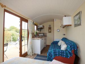 a room with a couch and a kitchen with a balcony at Llety'r Bugail 1 in Caernarfon