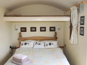 a bedroom with a bed with pillows on it at Llety'r Bugail 1 in Caernarfon