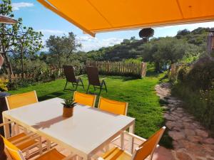 a table and chairs on a patio with an orange umbrella at El cielo de las Pajaritas in Pasarón