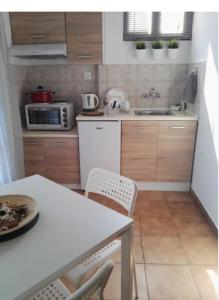 a kitchen with a table and chairs and a sink at Despoina House in Psakoudia