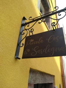 ein Schild an der Seite eines gelben Gebäudes in der Unterkunft Piccola Casa Di Sardegna in Villanova Monteleone