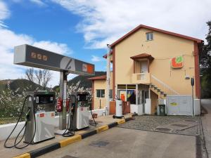 un distributore di benzina con macchine di fronte a un edificio di Hospedaria Lampião a Penacova