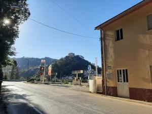 una calle vacía al lado de un edificio con una montaña en Hospedaria Lampião, en Penacova