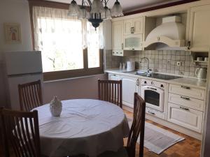 a kitchen with a table with chairs and a sink at Road View Apartment Celeia in Celje