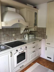 a kitchen with white cabinets and a stove top oven at Road View Apartment Celeia in Celje