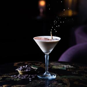 a martini glass with a candle on a table at Ice House Hotel in Ballina