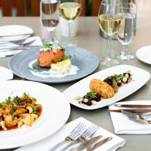 a table with plates of food and glasses of wine at Ice House Hotel in Ballina