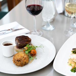 a table with two plates of food and a glass of wine at Ice House Hotel in Ballina