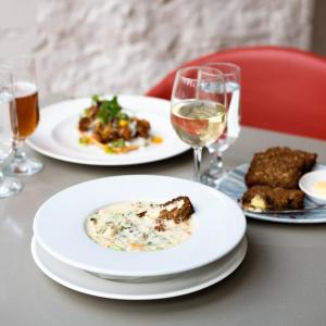 a table with plates of food and glasses of wine at Ice House Hotel in Ballina