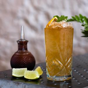 a drink on a table with lime slices at Ice House Hotel in Ballina
