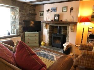a living room with a couch and a fireplace at Weardale Cottage in Saint Johns Chapel