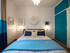 a bedroom with a blue and white bed and a chandelier at Mare Mio house on the Golfo Paradiso in Sori