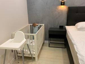 ein Baby steht in einem Kinderbett in einem Schlafzimmer in der Unterkunft Tammsaare Luxury Apartment in Pärnu