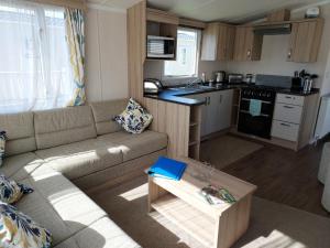 a living room with a couch and a kitchen at Shorefield Country Park Self-Catering Holiday Home in Lymington
