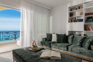 a living room with a green couch and a large window at Villa Bala - Seaside Luxury Villa! in Zakynthos Town