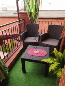 dwa krzesła i stół na balkonie z trawą w obiekcie Klinkierowa Komnata w Gnieźnie