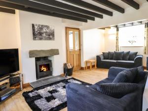 a living room with a couch and a fireplace at Tan Y Capel in Llanbrynmair