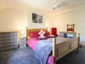 a bedroom with a bed and two night stands and a dresser at Tan Y Capel in Llanbrynmair