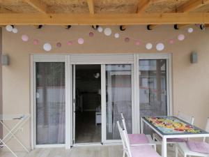 a patio with a table and chairs and pink balloons at Crystal Blue Apartments in Nea Kalikratia