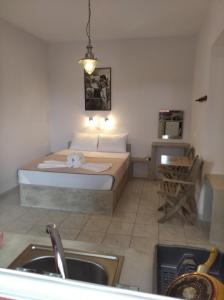 a bedroom with a bed and a kitchen with a sink at amorgaia3 in Katapola